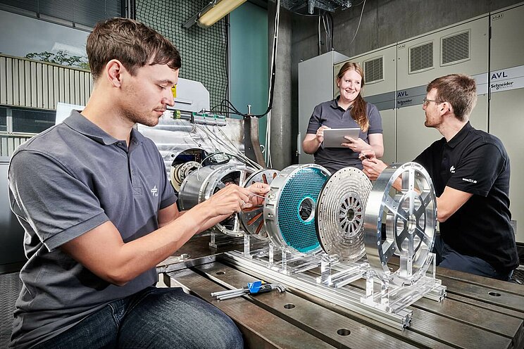 3 Personen arbeiten an einer Maschine.